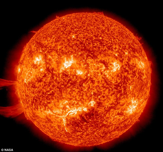 Danger: The massive solar flare, seen bursting from the Sun's surface, left, can play havoc with electrical equipment on Earth